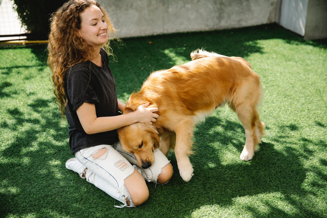 Girl with black and white dog covering one eye