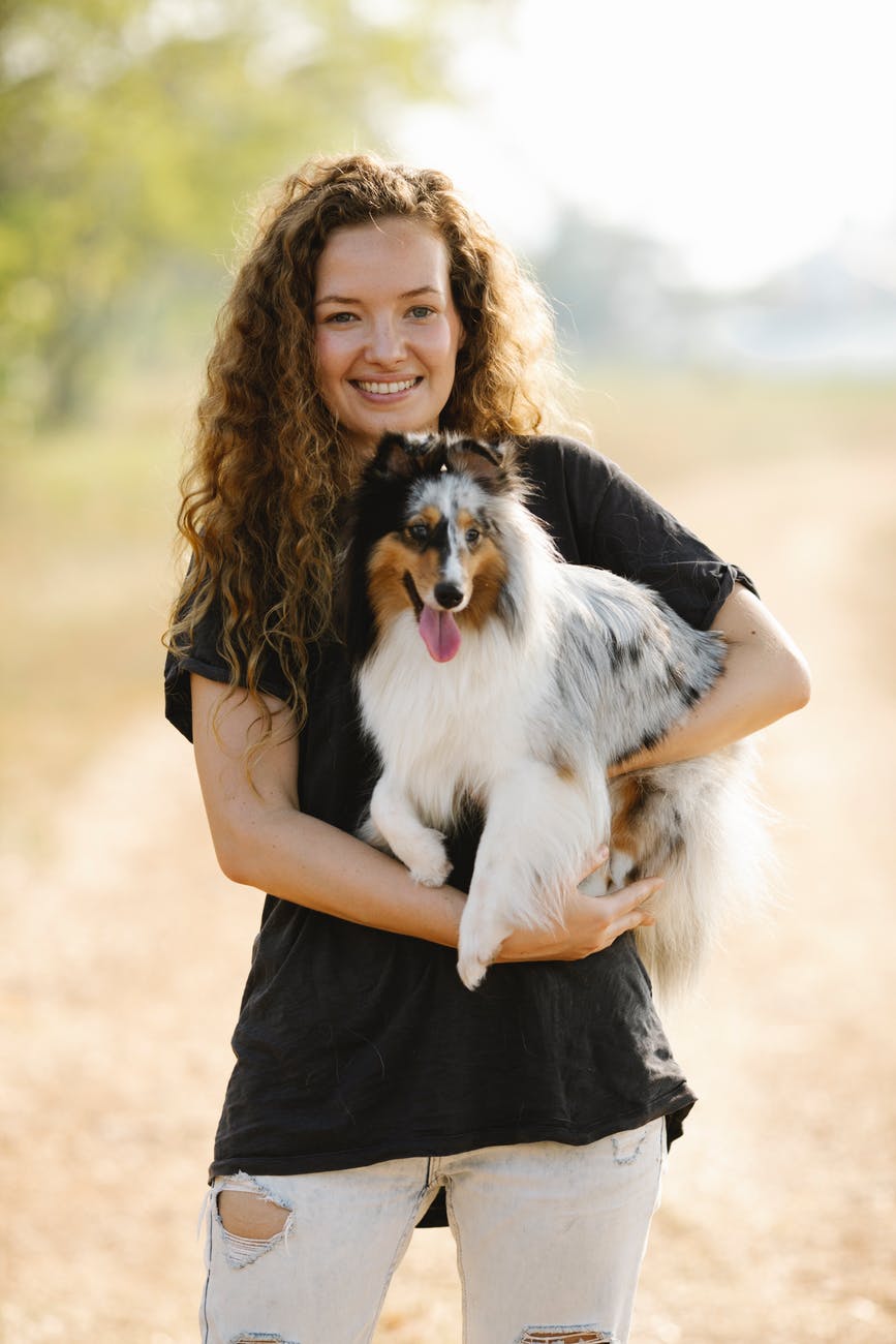 Woman holding Mini Australian Shepherd